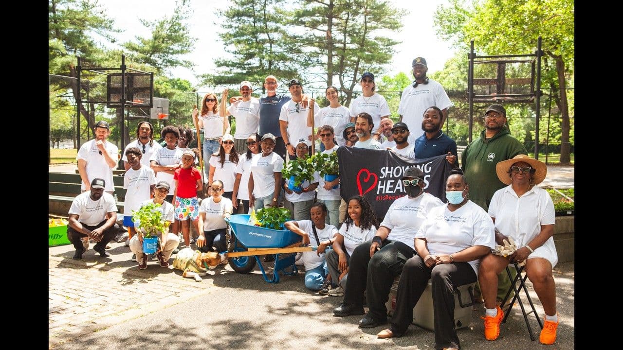 Showing Hearts Foundation volunteers gathered with the Showing Hearts banner at Peters Field in Hollis, Queens during Beautification 2026